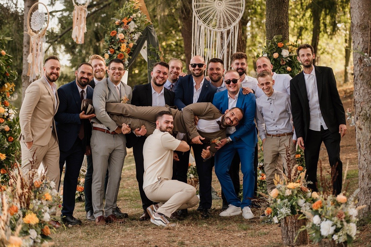 A groom and his groomsmen laughing together outdoors
