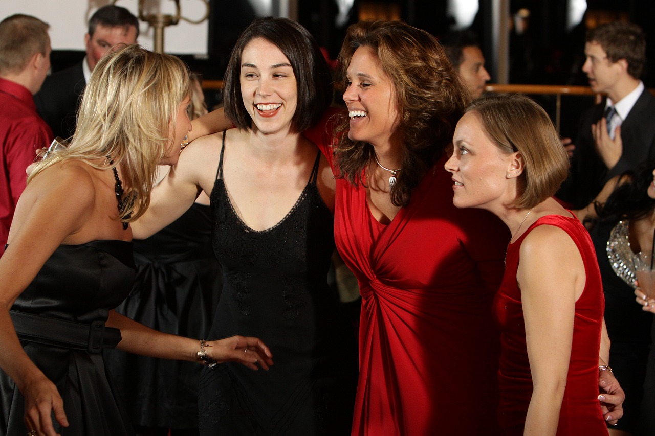 A group of women in party dresses laughing together on a night out